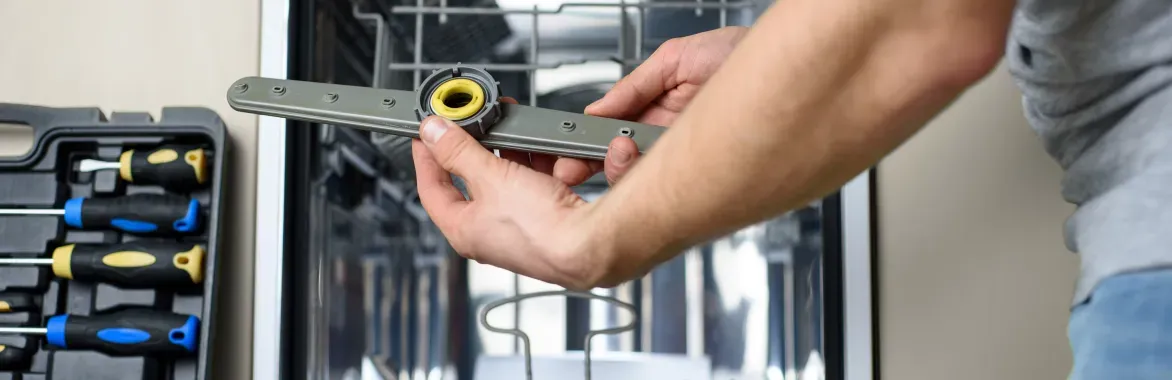 handyman-closeup-holding-dishwasher-part